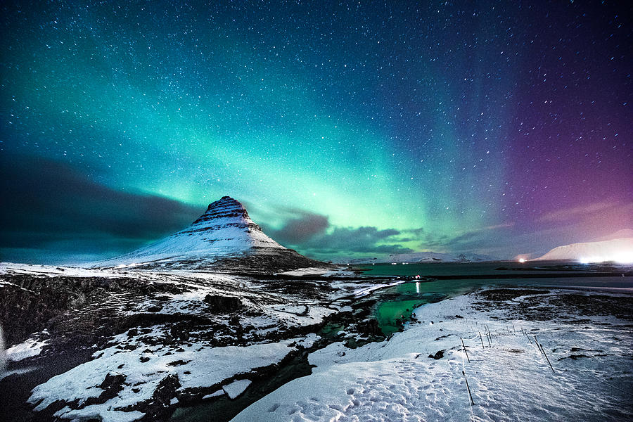 Northern lights in Mount Kirkjufell Iceland with a man passing by #1 Photograph by LeoPatrizi