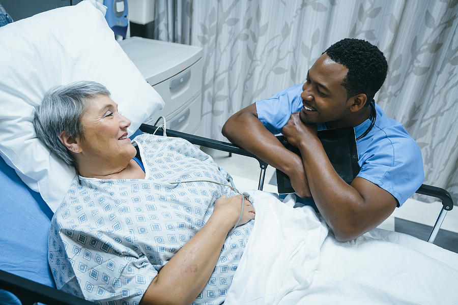 Nurse talking to patient in hospital bed #1 Photograph by FS Productions