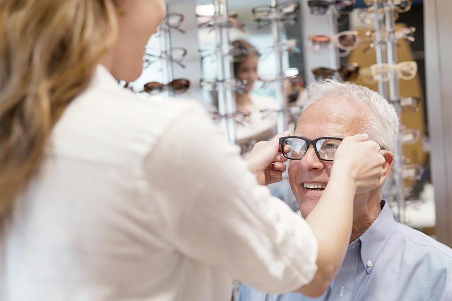 Optician Putting Glasses On Senior Man Photograph by Science Photo ...