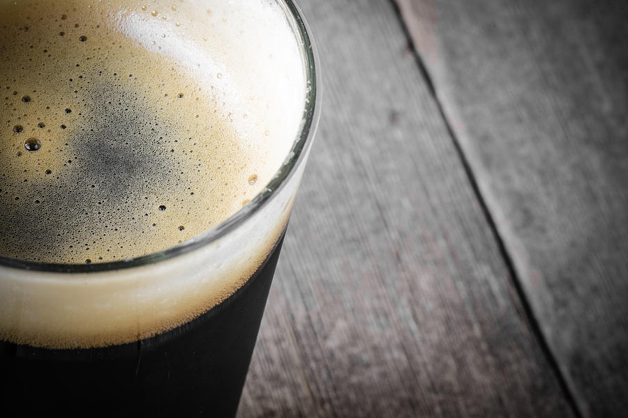 Pint of Dark Beer on Wood Background #1 Photograph by Brandon Bourdages