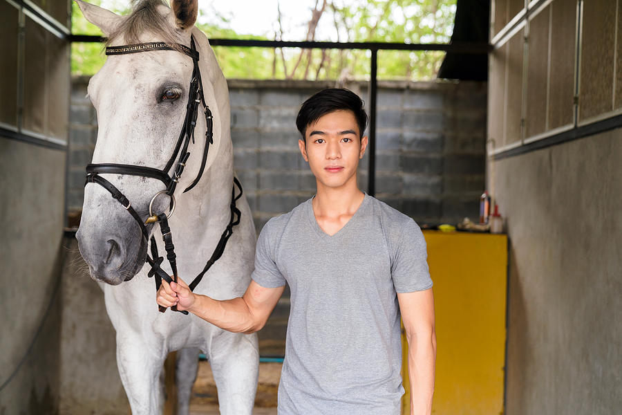 Portrait of a young male horse rider stood with his horse #1 Photograph by JGalione