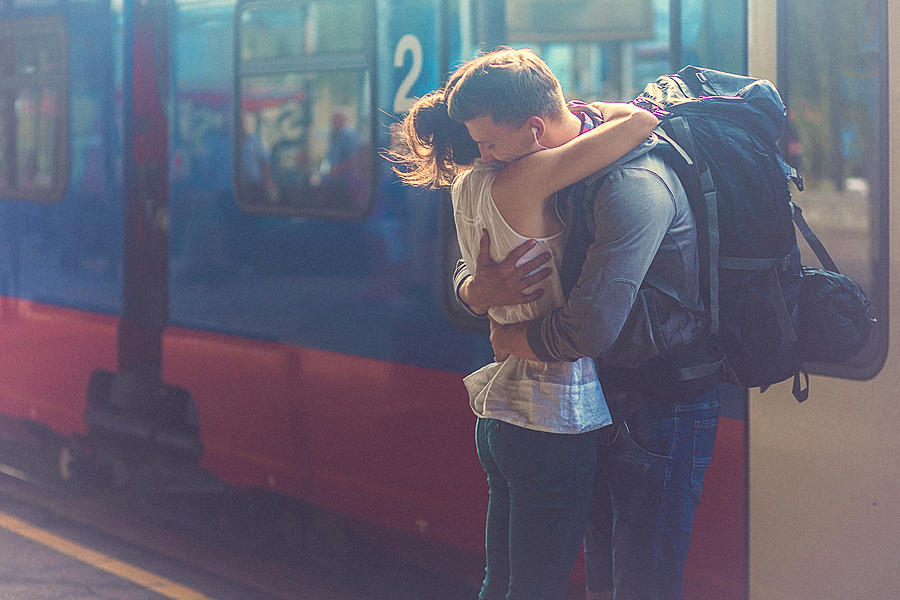 Portrait of woman and man embracing at the railway platform #1 Photograph by Gruizza