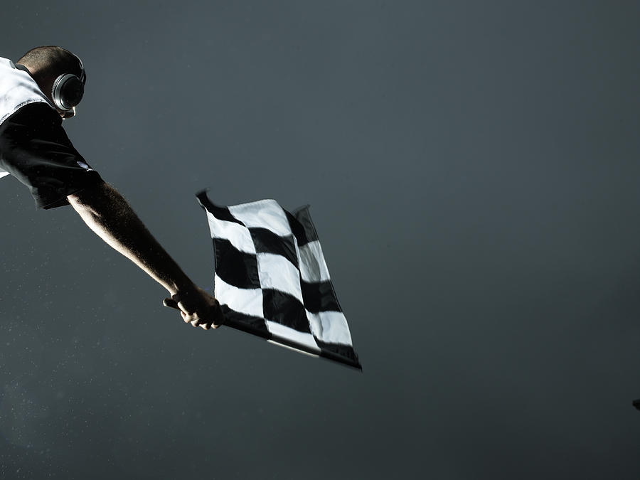 Racing official waving checkered flag #1 Photograph by Hans Neleman