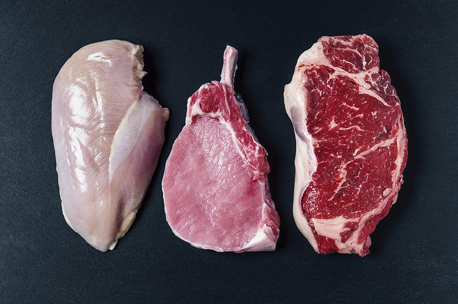Raw meat (chicken breast, pork chop, and beef steak) Photograph by Claudia Totir