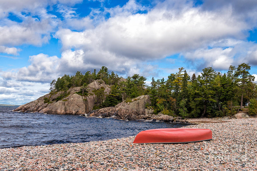 Red canoe on a pebble beach #1 Photograph by Les Palenik