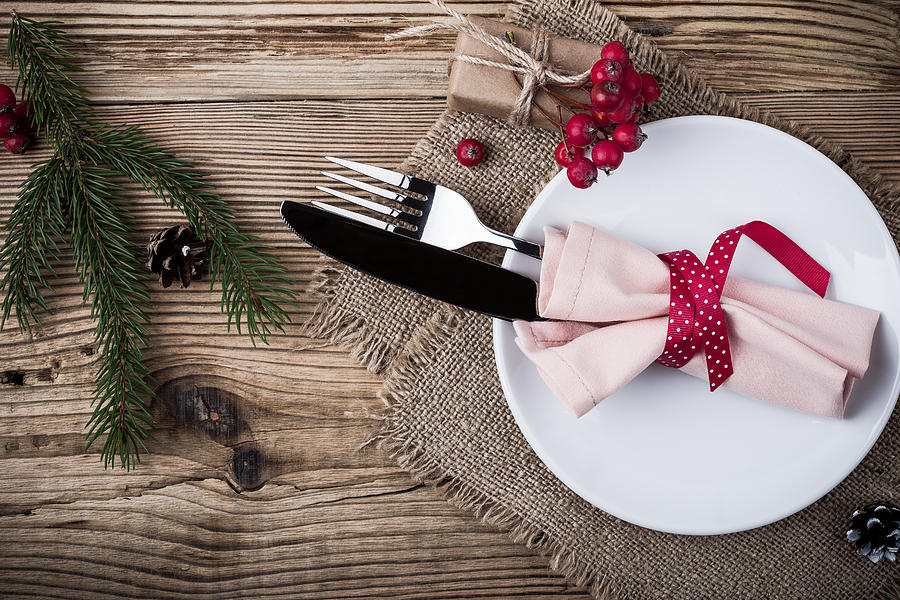 Rustic Christmas place setting,  plate, knife and fork wrapped with napkin on rustic wooden table, top view. Winter holiday theme,  Happy New Year decoration with copy space #1 Photograph by Istetiana
