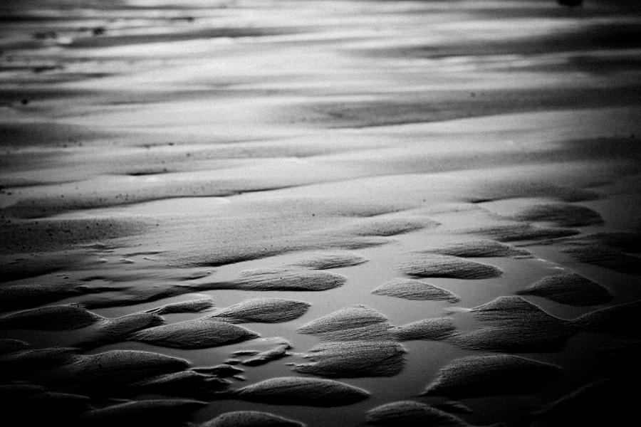 Rythm on sand with wave on sea coast at sunset bw #1 Photograph by Raimond Klavins