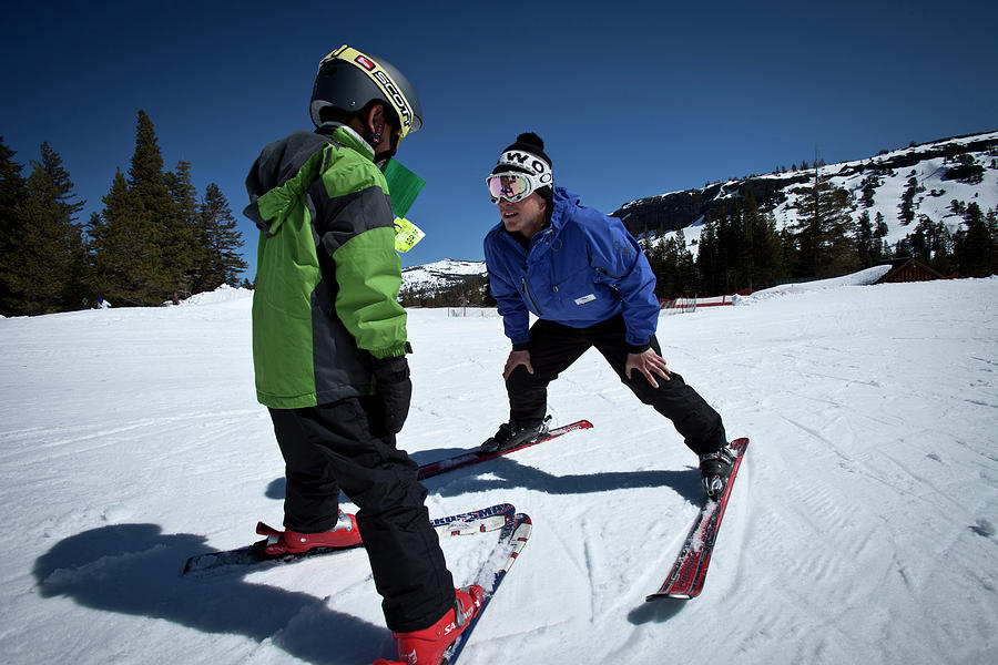 Ski Instructor Helping A Young Skier Photograph by Trevor Clark - Fine ...