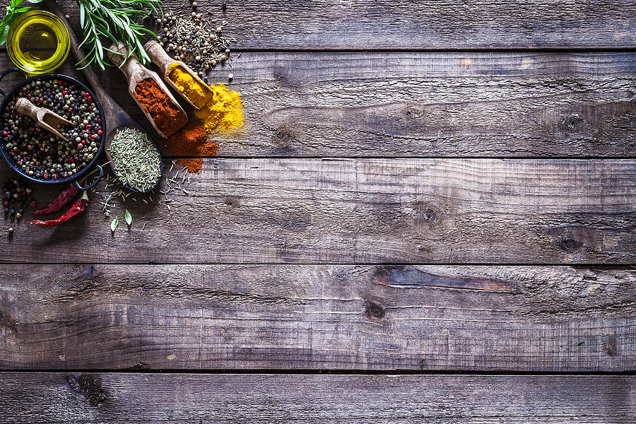 Spices and herbs on rustic wood kitchen table #1 Photograph by Fcafotodigital