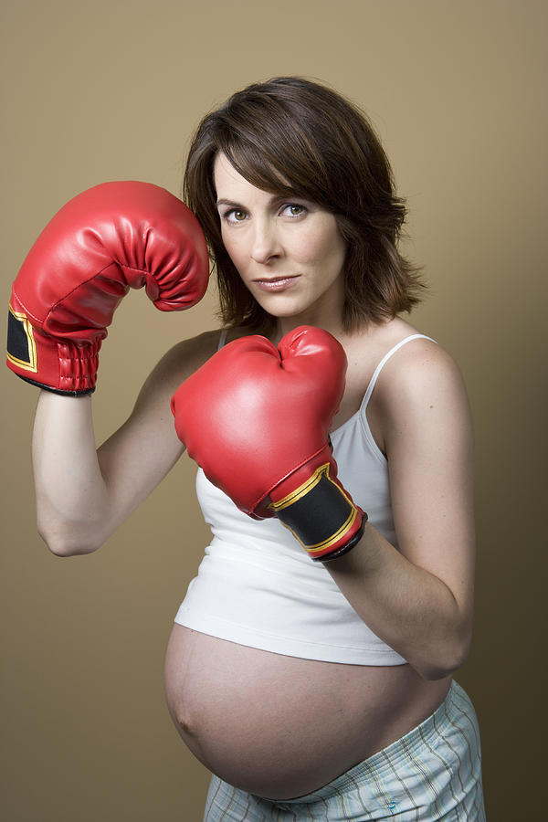 Studio portrait of pregnant woman wearing boxing gloves #1 Photograph by Sheer Photo, Inc