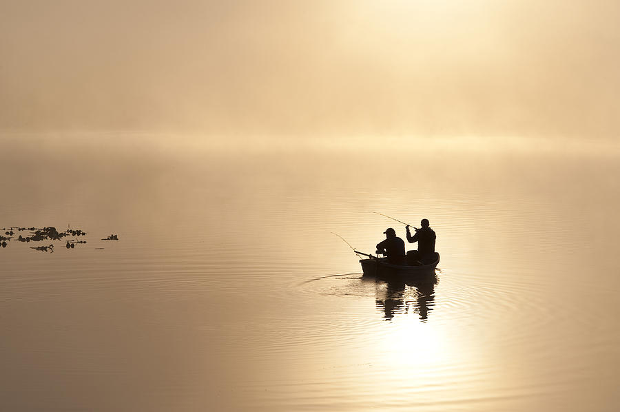 Sunrise in fog Lake Cassidy with fishermen in small fishing boat ...