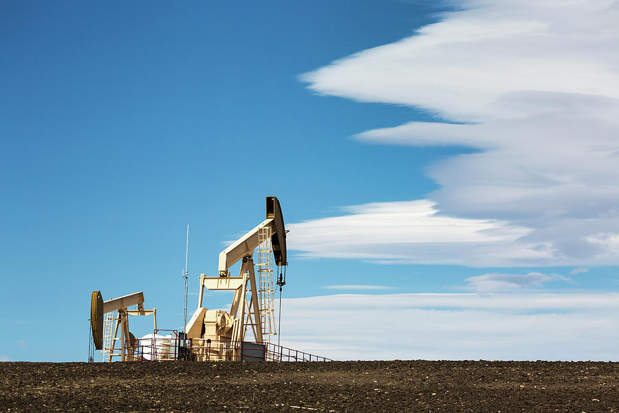 Two Pumpjacks On A Hill With Dramatic #1 Photograph by Michael Interisano
