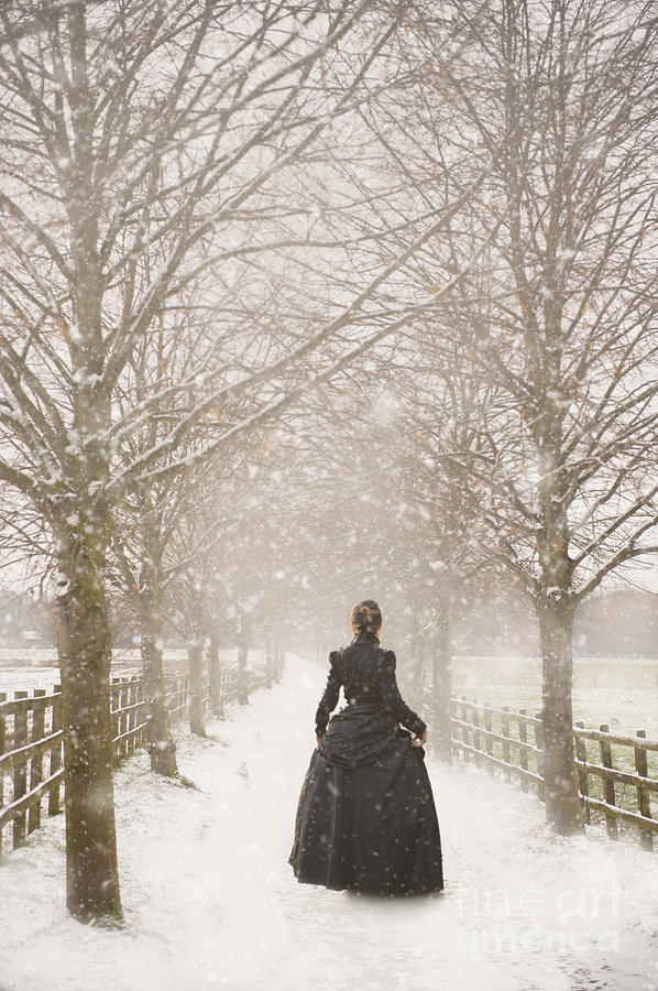 Victorian Woman Walking A Tree Lined Avenue In Snow #1 Photograph by Lee Avison
