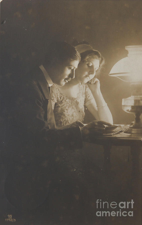 Vintage loving couple reading with oil lamp Photograph by Patricia Hofmeester
