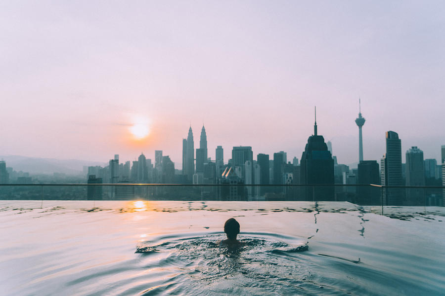 Woman in the swimming pool with view of Kuala Lumpur #1 Photograph by Oleh_Slobodeniuk