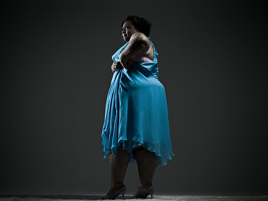 Woman struggling with dress #1 Photograph by Image Source