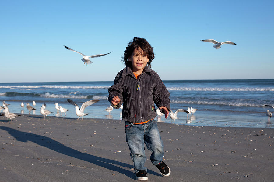 Nature Photograph - Young Boys Feed Seagulls On The Beach #1 by Logan Mock-Bunting
