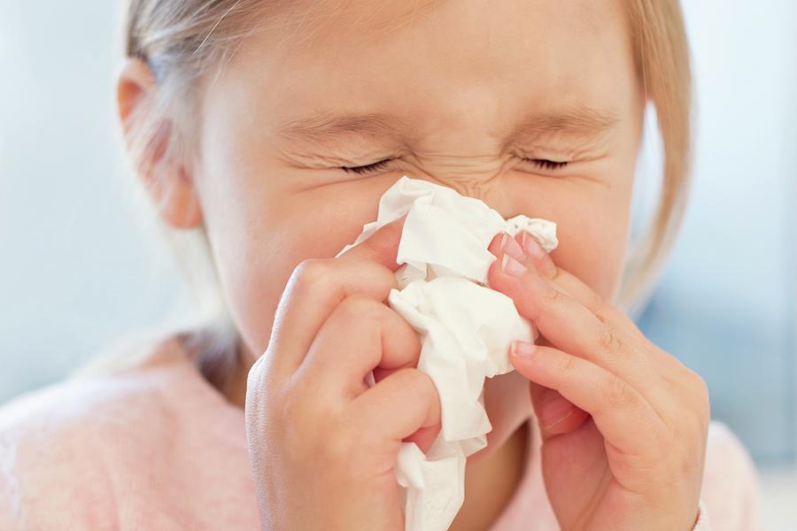 Young Girl Sneezing Into Tissue #1 by Science Photo Library