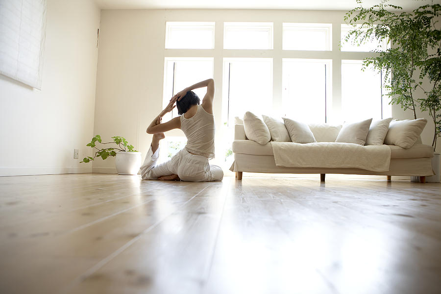 Young woman performing yoga pose in living room #1 Photograph by Ultra F