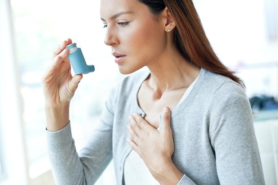 Young Woman Using Inhaler Touching Chest #1 Photograph by Science Photo ...