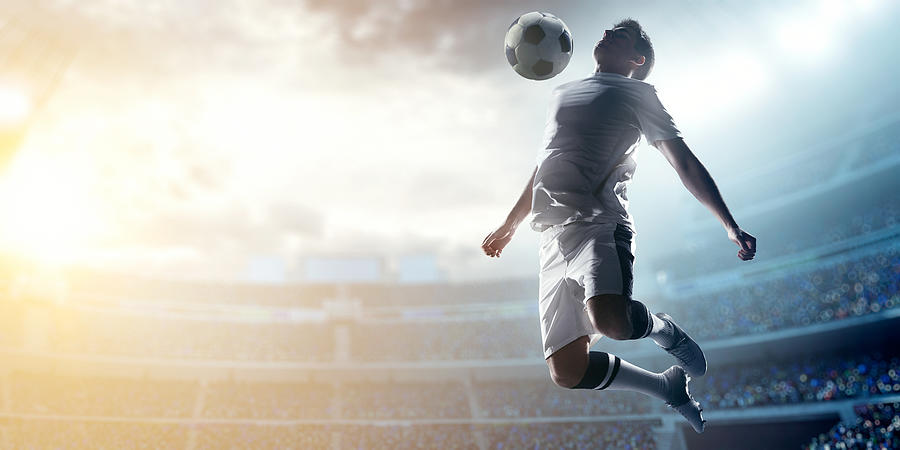 Soccer player kicking ball in stadium #10 Photograph by Dmytro Aksonov