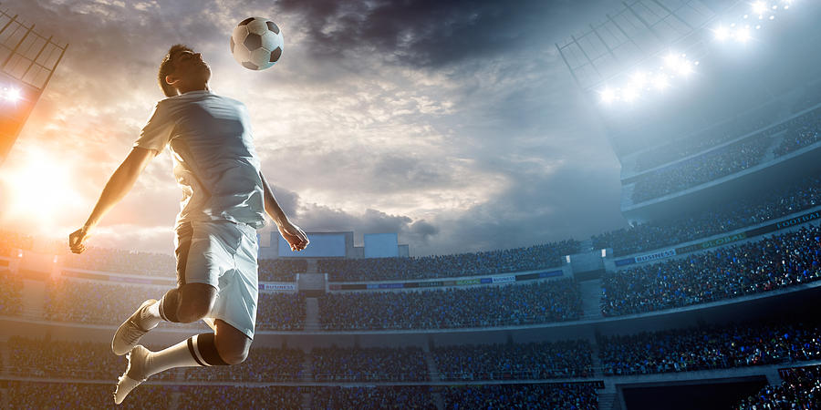 Soccer player kicking ball in stadium #12 Photograph by Dmytro Aksonov