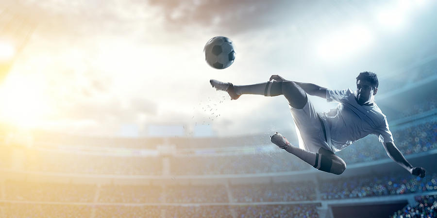 Soccer player kicking ball in stadium #17 Photograph by Dmytro Aksonov