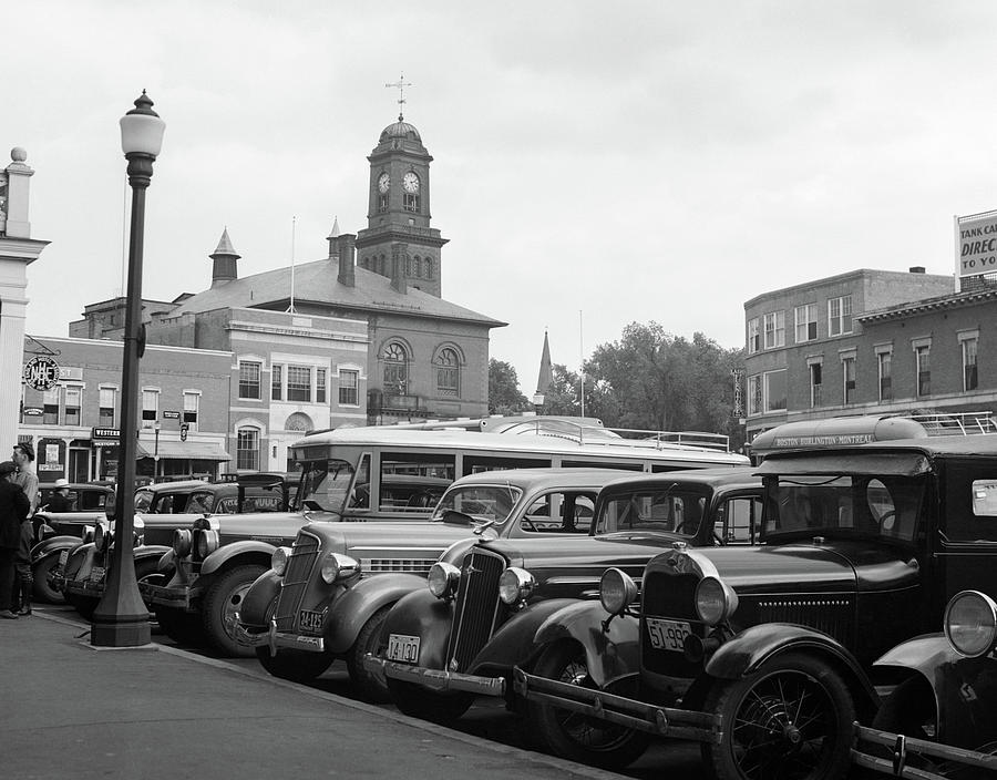 Black And White Photograph - 1930s Buses Cars Parked Small Town by Vintage Images