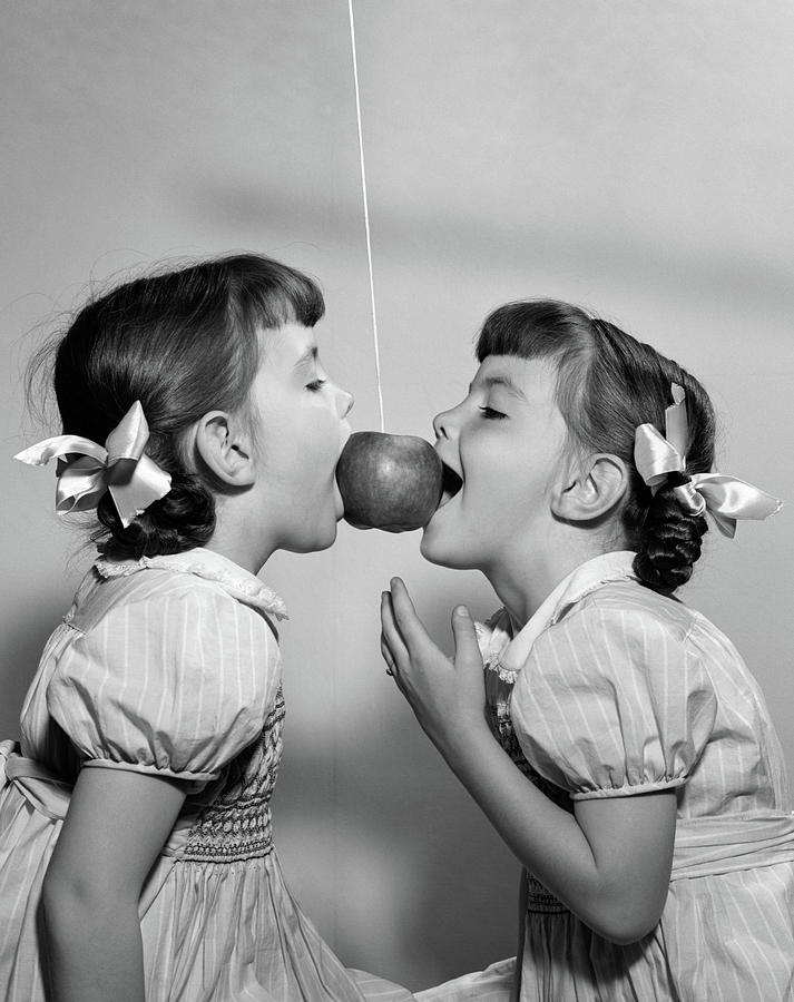 Black And White Photograph - 1940s 1950s Twin Girls Trying To Eat by Vintage Images