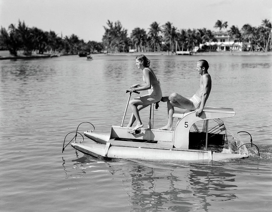 Black And White Photograph - 1940s Couple On Pontoon Pedal Boat by Vintage Images