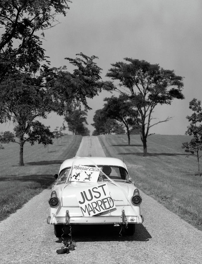 Black And White Photograph - 1950s Back Of White Ford Sedan Driving by Vintage Images