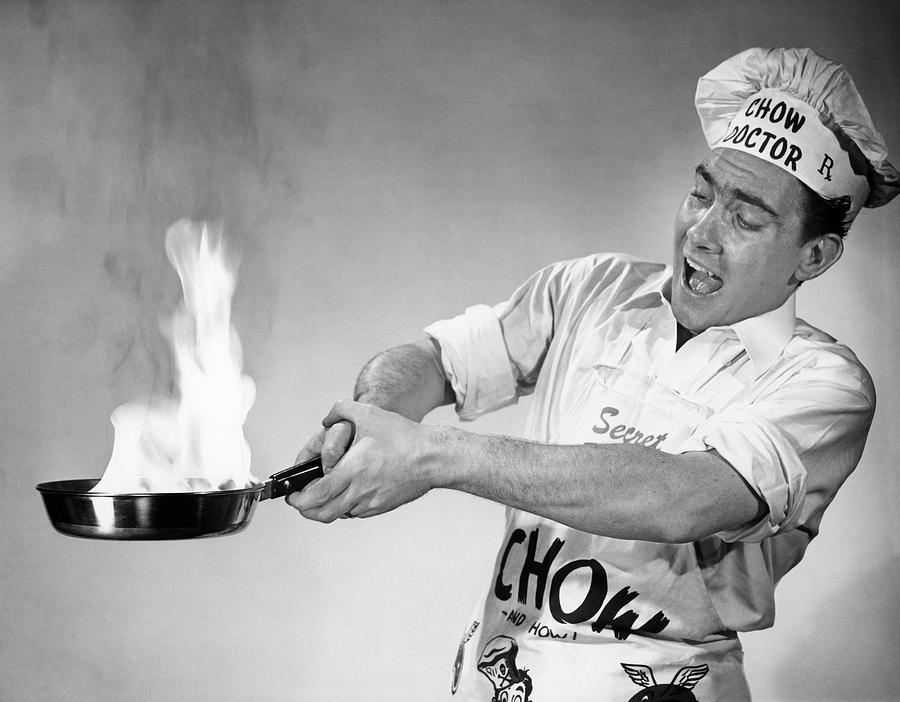 Black And White Photograph - 1950s Frantic Man Flaming Skillet Fry by Vintage Images