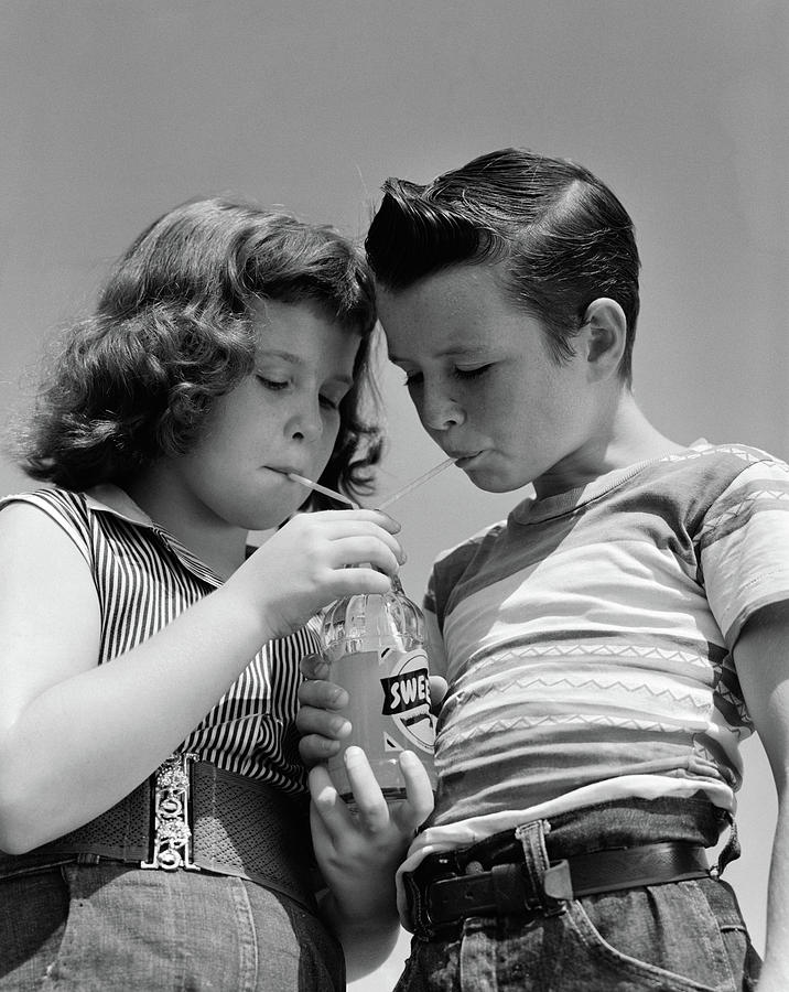 Black And White Photograph - 1950s Girl And Boy Share Soda Two by Vintage Images