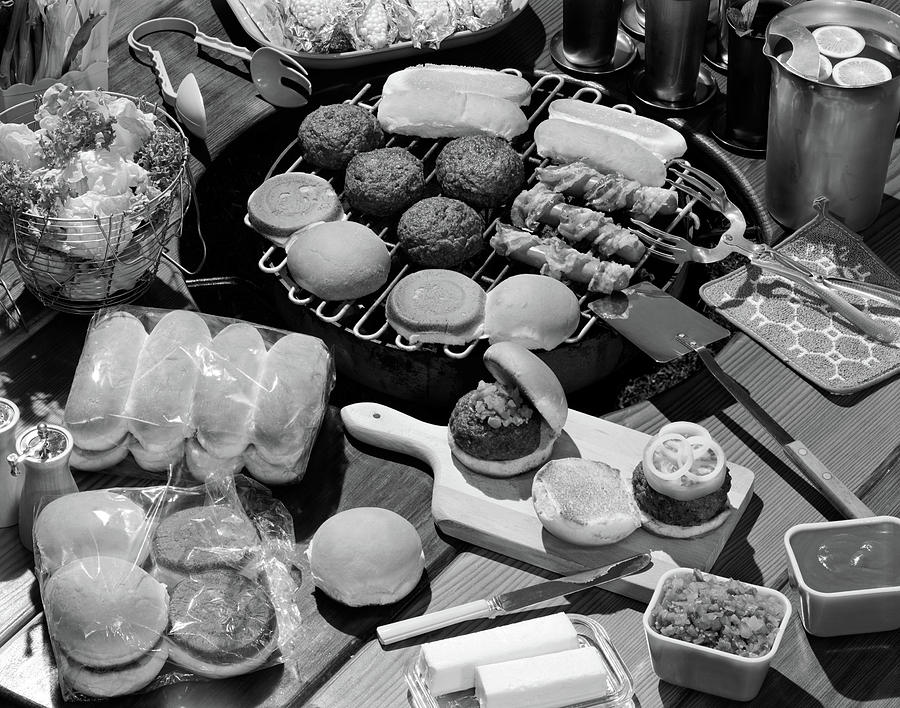Black And White Photograph - 1950s Hamburgers Hot Dogs Buns Cookout by Vintage Images