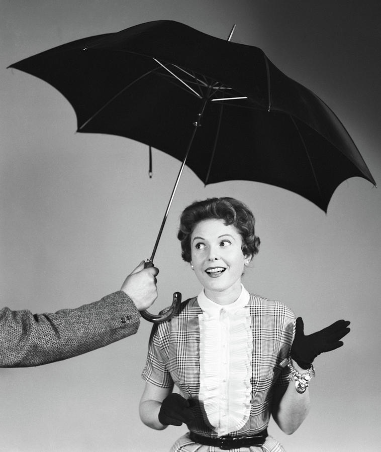 Black And White Photograph - 1950s Unseen Man Hold Out Umbrella by Vintage Images