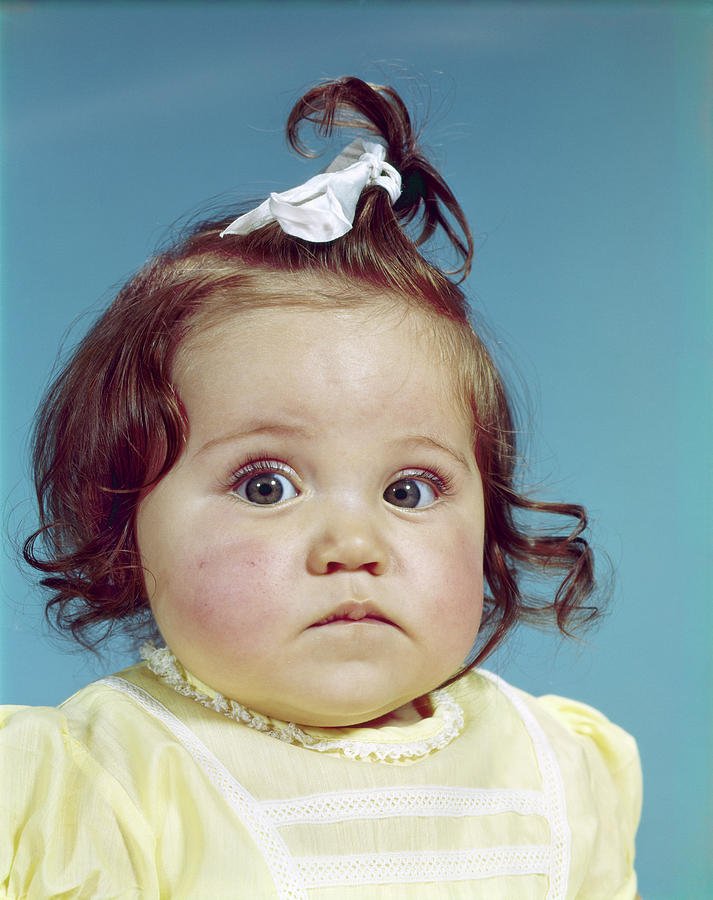 Portrait Photograph - 1960s Brunette Baby Girl Ribbon Topknot by Vintage Images