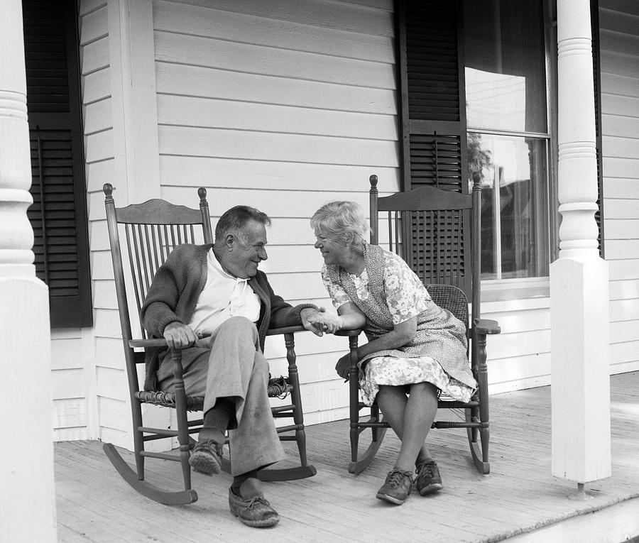 Black And White Photograph - 1970s Elderly Couple In Rocking Chairs by Vintage Images