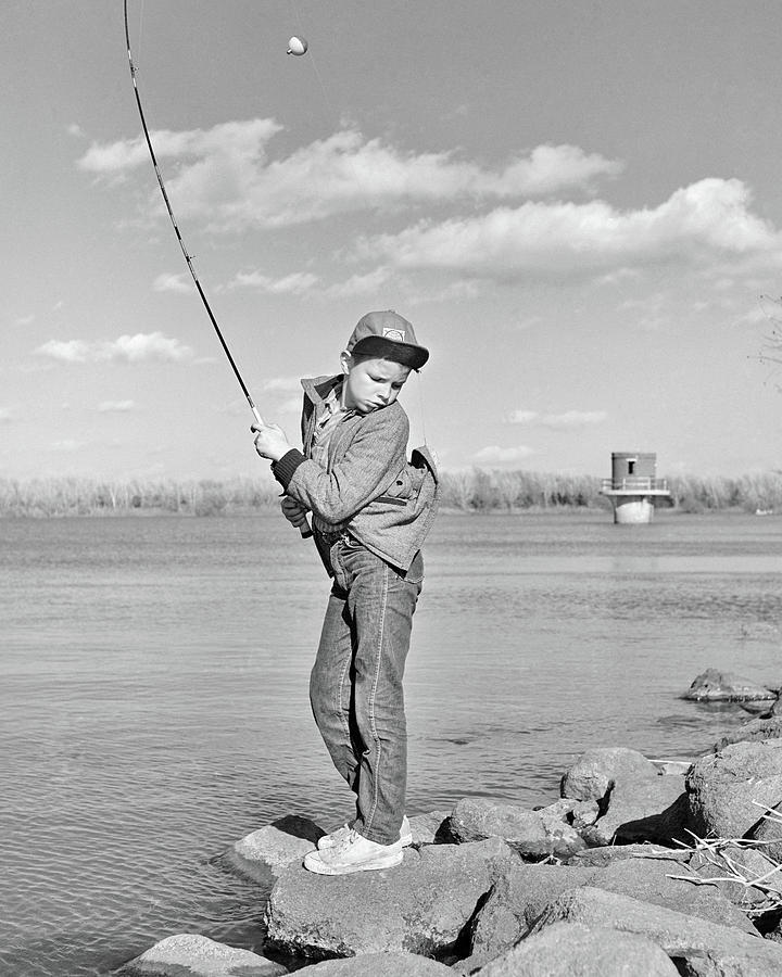 1980s Boy Fishing On Riverbank by Vintage Images