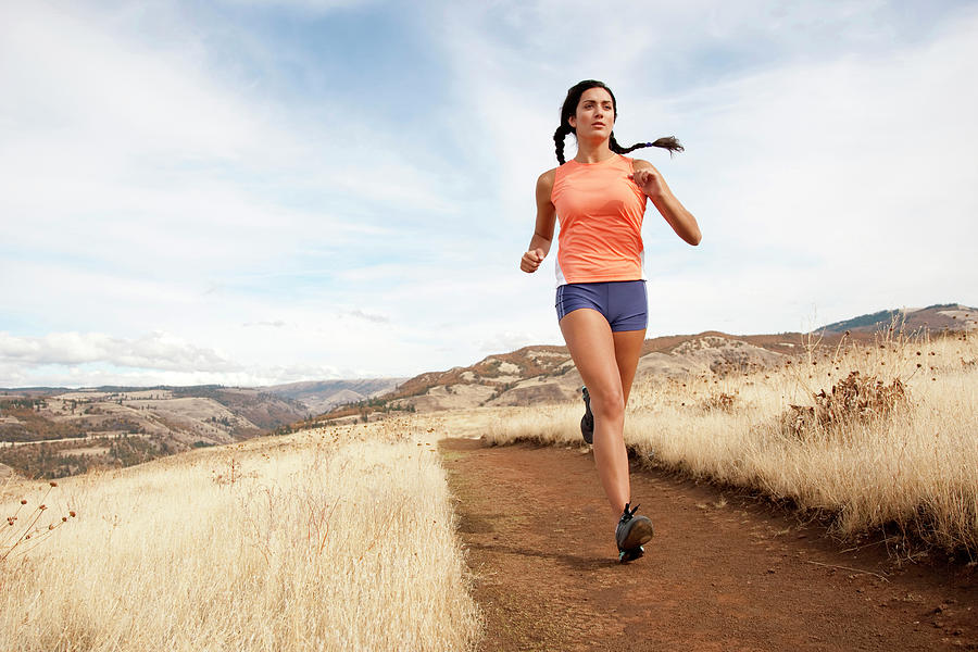 An Athletic Female Jogs On A Dirt Photograph by Jordan Siemens - Pixels