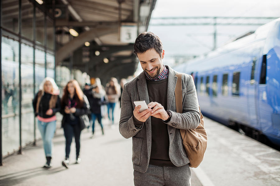 Businessman using mobile phone at train station Photograph by Geber86 Businessman using mobile phone at train station Photograph by Geber86