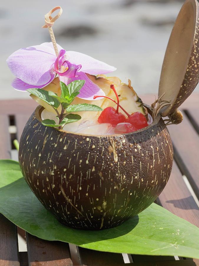 Coconut Drink With Pineapple, Cocktail Cherry And Orchid Photograph by ...