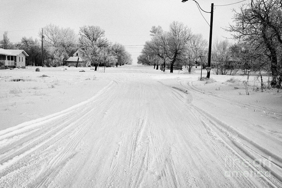 Winter Photograph - empty intersection on snow covered street in small rural farming community village Forget Saskatchew #2 by Joe Fox