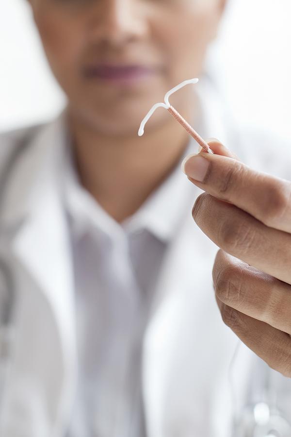 Female doctor holding an IUD #2 Photograph by Science Photo Library