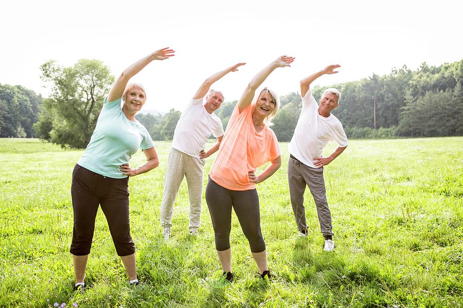 Four People In Field Exercising Photograph by Science Photo Library ...