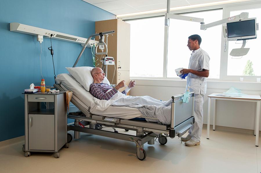 Male Nurse Talking To Senior Man Photograph By Arno Massee Science