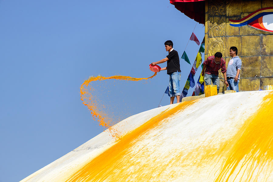 Man throwing orange paint on Boudhanath stupa #2 Photograph by Dutourdumonde Photography