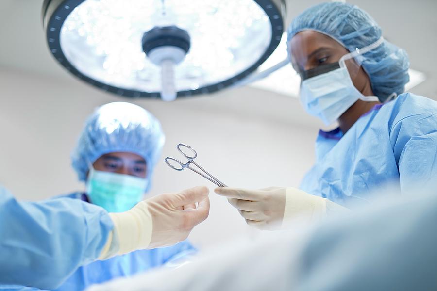 Nurse Passing Surgical Scissors To Surgeon Photograph by Science Photo ...