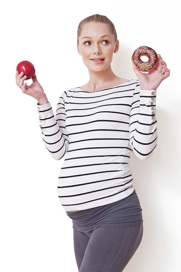 Pregnant Woman Holding Apple And Doughnut #2 Photograph by Ian Hooton/science Photo Library