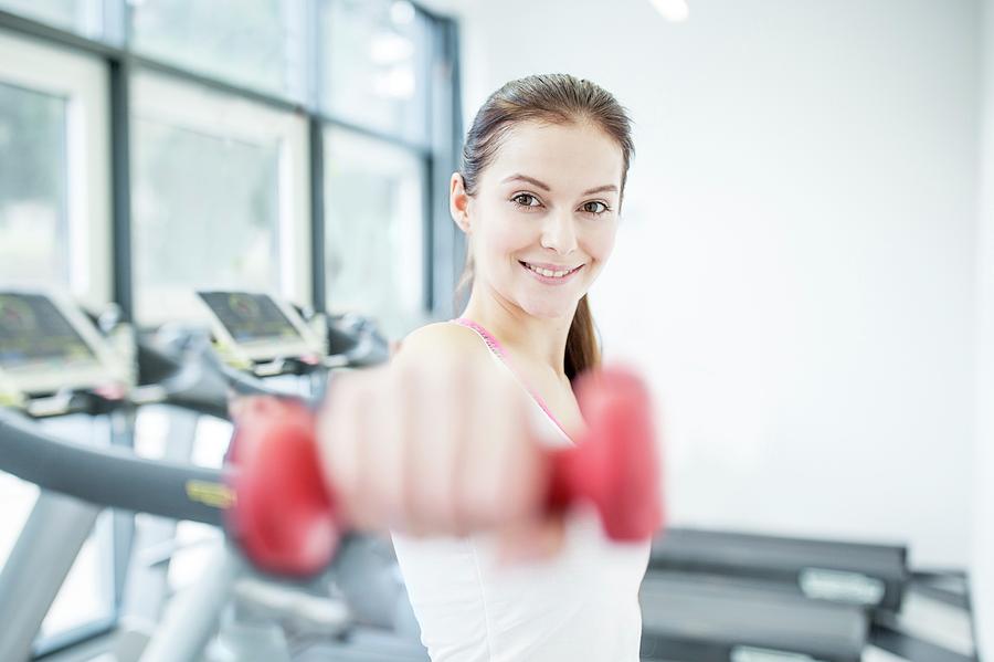 Smiling Young Woman Holding Dumbbell Photograph by Science Photo ...