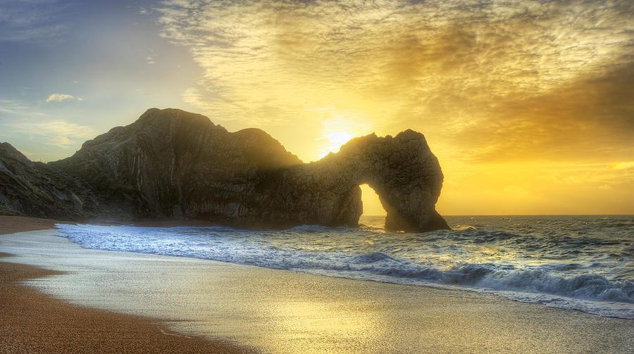 Vibrant sunrise over ocean with rock stack in foreground Photograph by ...